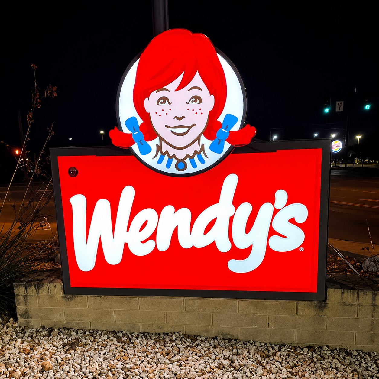 Bright front-lit commercial monument sign at night