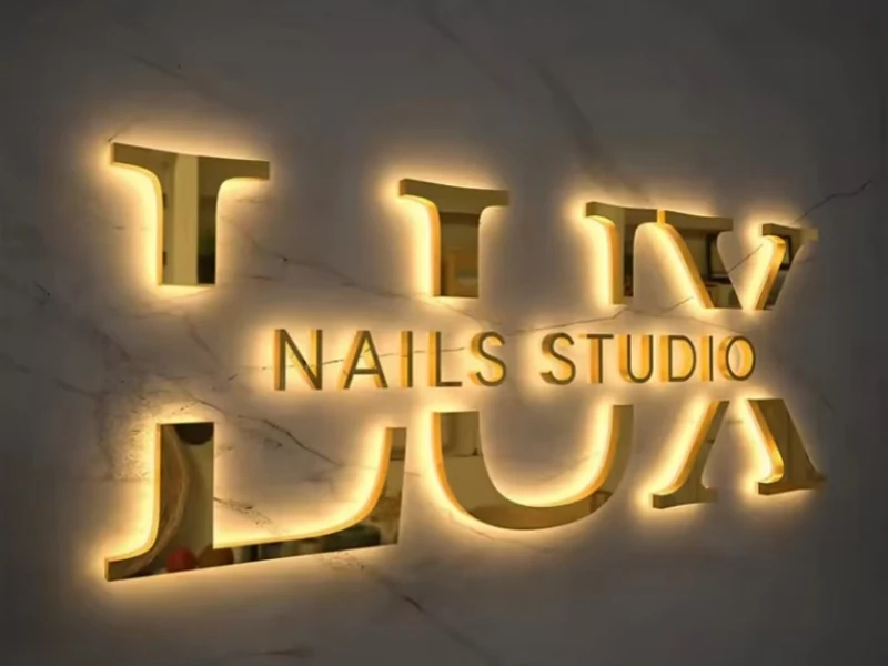 Warm halo-lit metal letters for a nail studio
