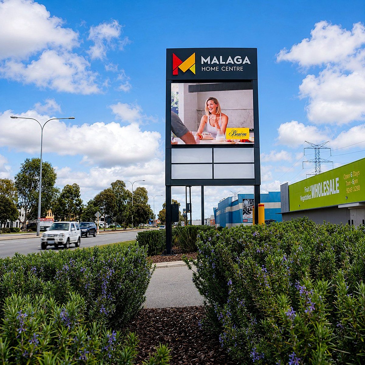 Tall freestanding digital pylon installed on a roadside site with clearance between structure and ground-level landscaping. Tall freestanding digital pylon installed on a roadside site with clearance between structure and ground-level landscaping.