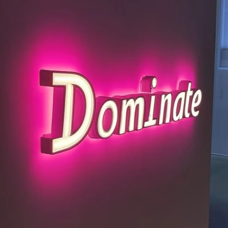 Pink halo-lit outdoor channel letters on a dark wall