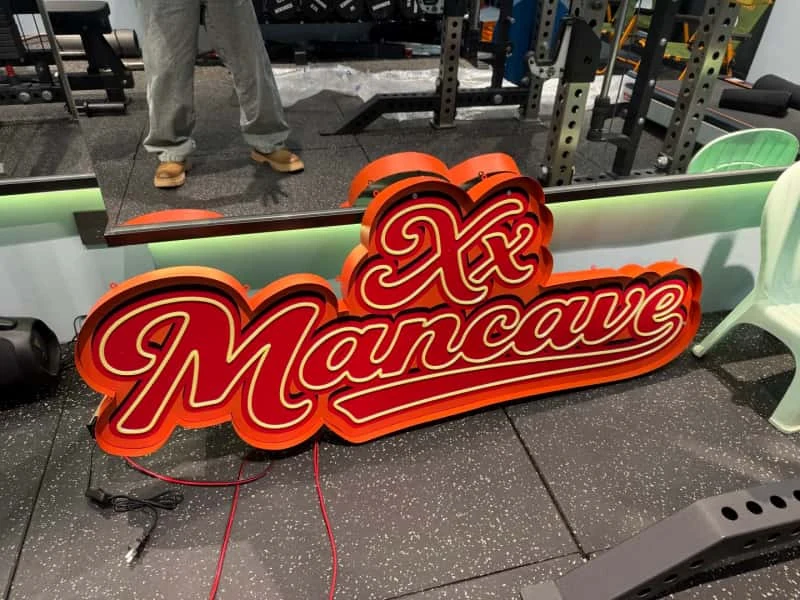 Red script metal sign under fabrication