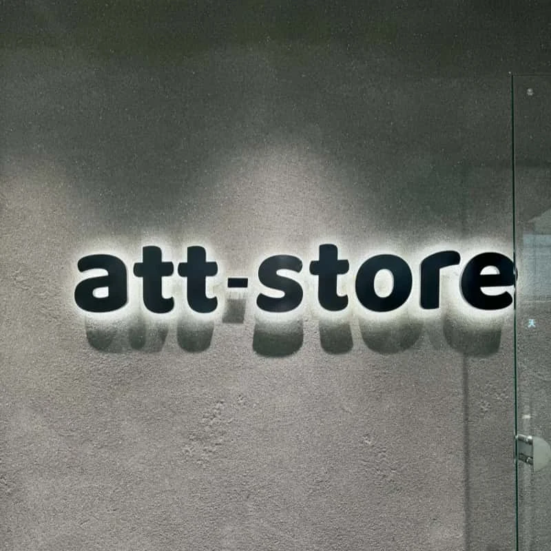 White halo-lit store letters on a dark wall