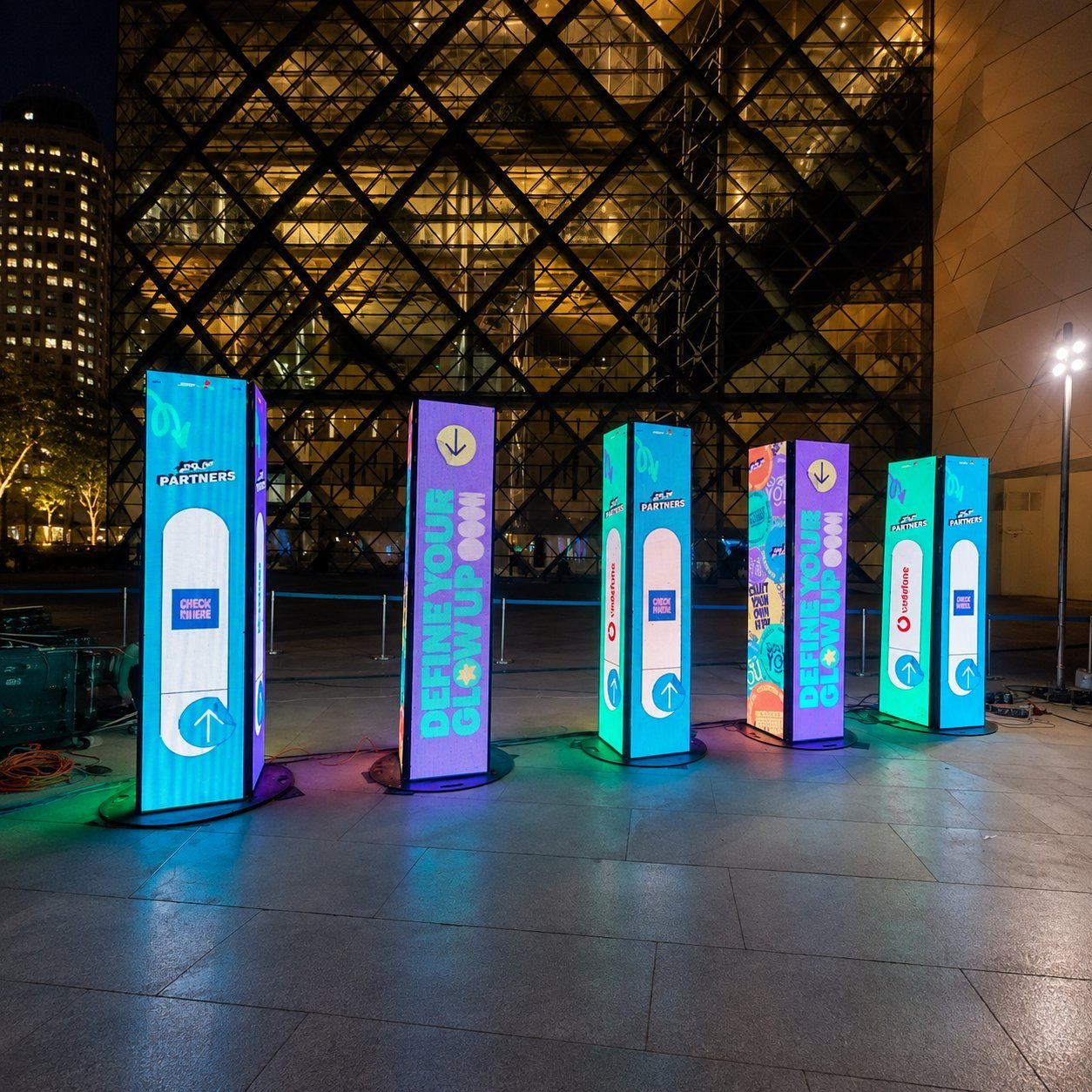 Outdoor LED Installation Array Freestanding illuminated LED columns arranged in an outdoor public space.