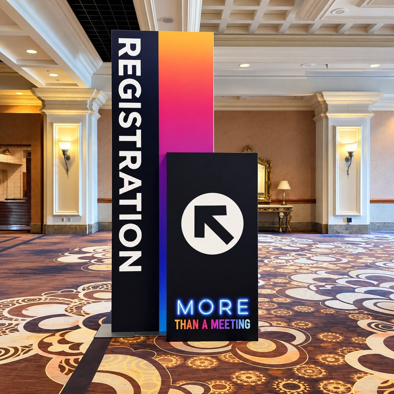 A tall neon-style Registration sign with the text MORE THAN A MEETING, displayed in a hotel conference lobby on patterned carpet.