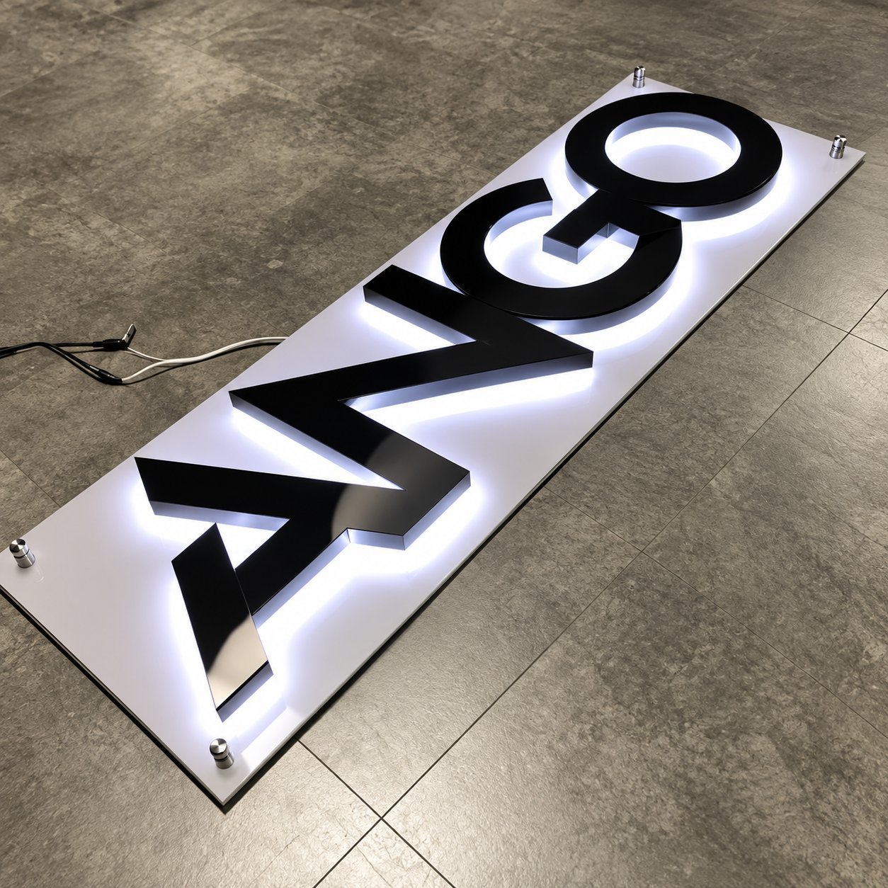 Black backlit channel letters mounted on a white acrylic backplate with visible LED halo lighting.