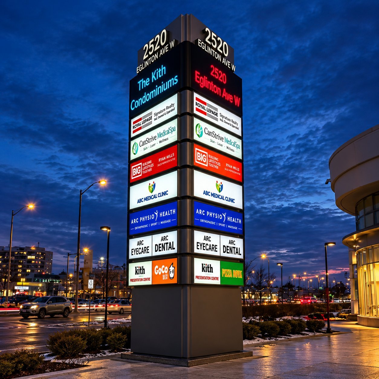 Multi-Face Directory Pylon at Dusk Tall illuminated directory pylon at dusk displaying stacked tenant signs on multiple faces.