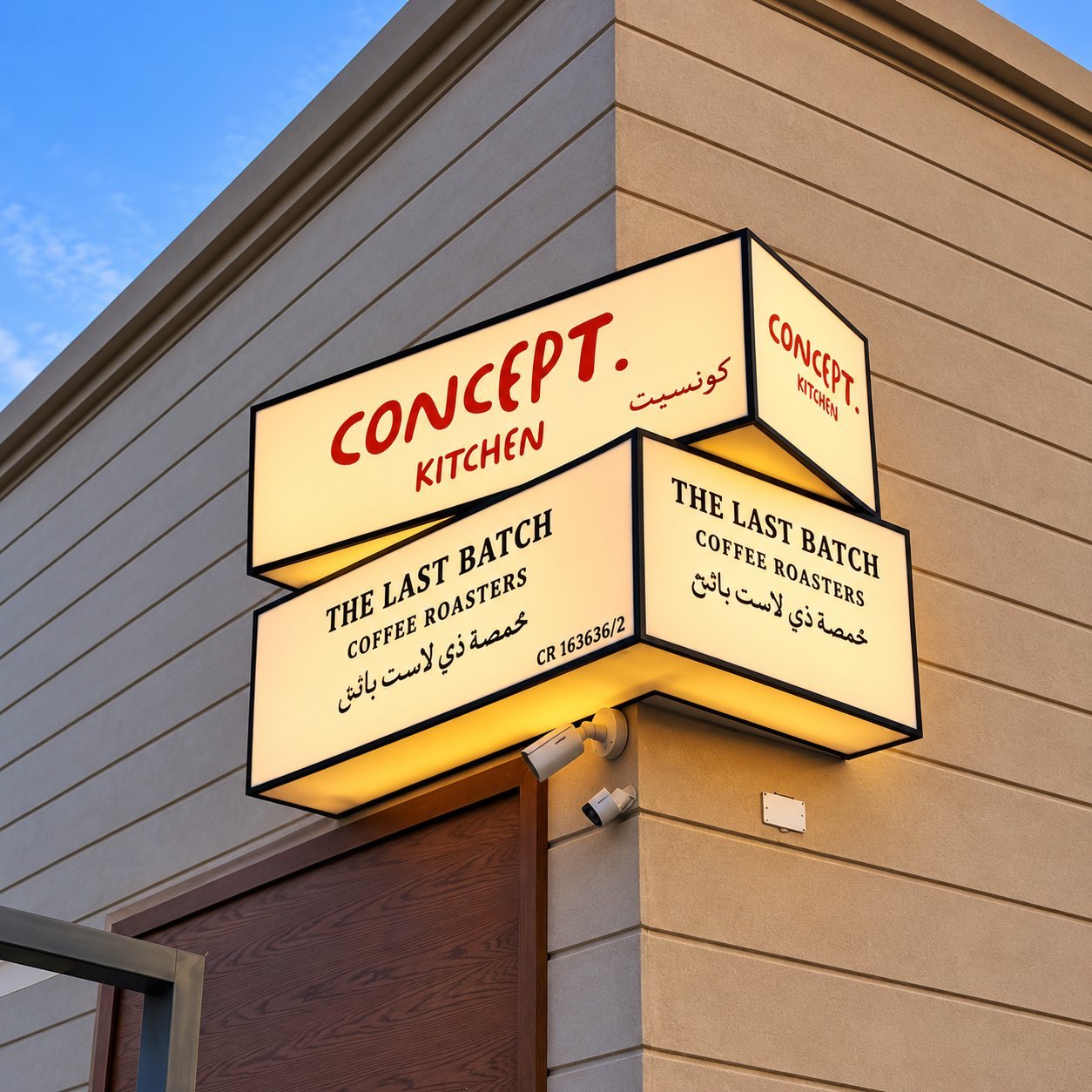 Concept Kitchen backlit lightbox sign on a corner facade with bilingual script and brand mark.