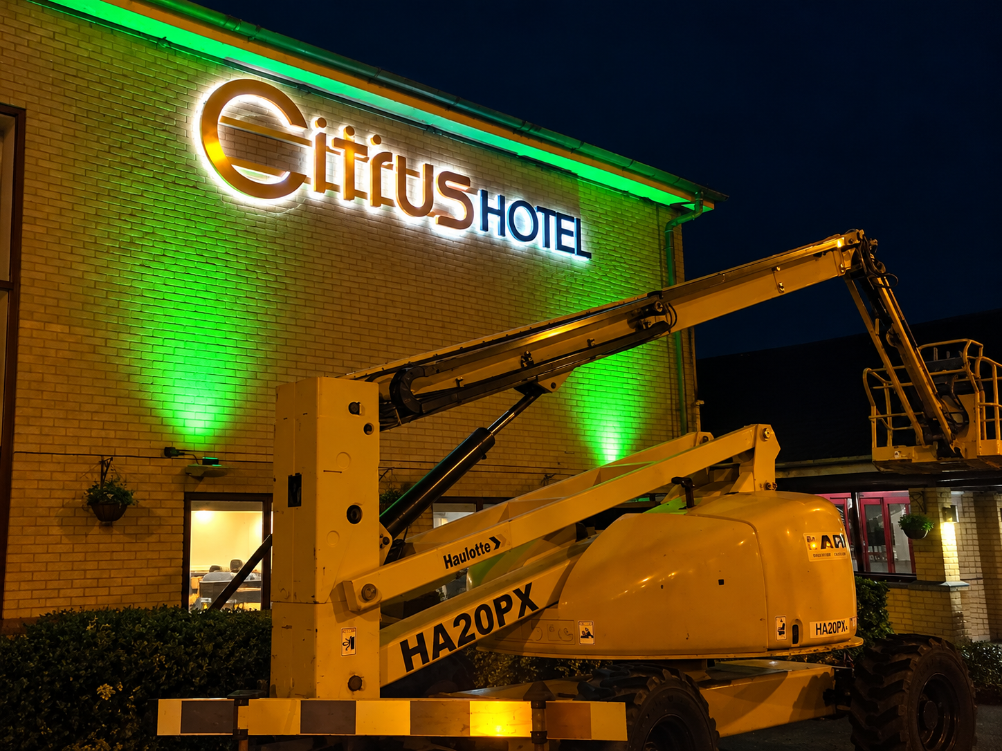 Illuminated 3D hotel sign letters on a building facade at night