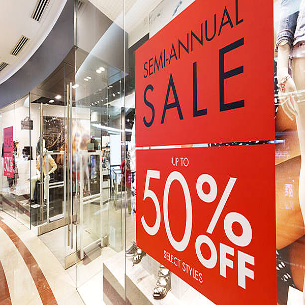Promotional storefront window decals and graphics advertising a sale event