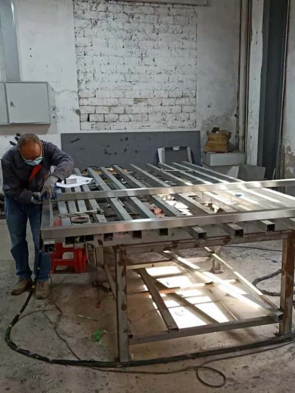 Worker Welding Metal Sign Frame In Factory